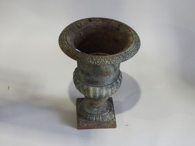 un petit vase en métal posé sur une table