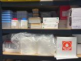 many boxes and containers on a shelf in a room