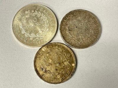 three different types of coins sitting next to each other on a white surface