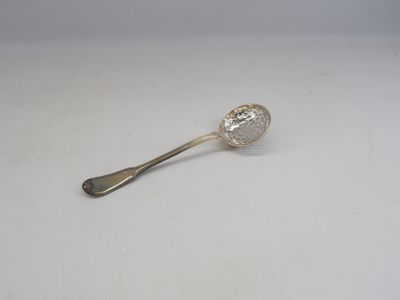 une cuillère en argent posée sur une surface blanche, avec une cuillère en argent au milieu