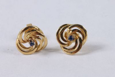 a close up of a pair of gold earrings with blue stones