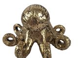 an image of a gold octopus figurine sitting on top of a white surface
