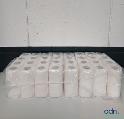 Plusieurs rouleaux de papier toilette sont emballés dans des sacs en plastique sur un comptoir