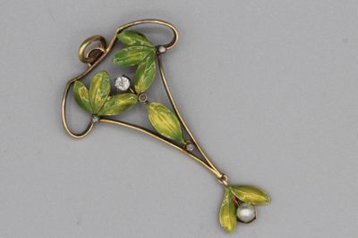 une image représentant une broche ornée de feuilles et d'une perle