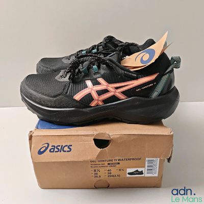 black and pink asics tennis shoes on top of a box