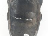 a wooden mask on a white background with a tag