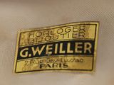 the label on the back of a white jacket with a gold and black logo