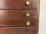 a small wooden chest of drawers with brass knobs
