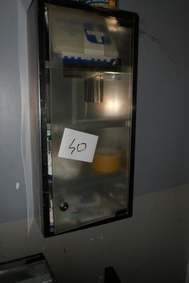 un petit réfrigérateur sur lequel est accrochée une affiche, dans un coin de la pièce