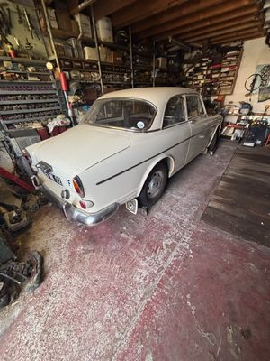 une voiture garée dans un garage à côté d'une moto