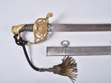 an old sword with a gold handle and a tassel on a white surface