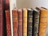 many old books on a shelf next to each other