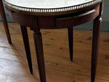 une table au plateau en marbre posée sur un parquet en bois massif