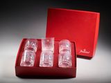 trois verres vides dans une boîte rouge, avec une autre boîte rouge derrière eux