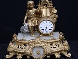 a gold clock sitting on top of a marble base