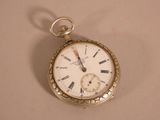 a gold pocket watch with roman numerals on it