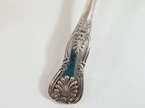a silver spoon with a blue handle sitting on a table