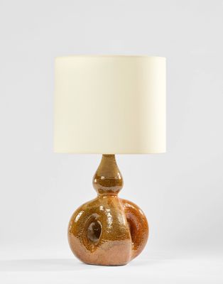 une lampe de table marron surmontée d'un abat-jour blanc
