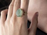 quelqu'un porte une bague sertie d'une pierre verte