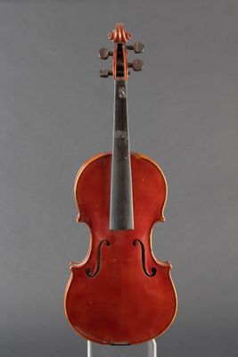 an old violin sitting on a stand against a gray background