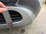 a person holding a measuring tape in front of a car