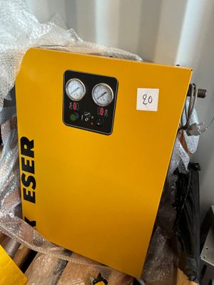 a yellow air compressor sitting on top of a pallet