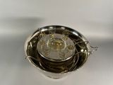 a silver plate with a glass on top of it