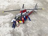 un hélicoptère miniature posé par terre, avec des personnes autour