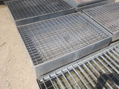 plusieurs grilles métalliques sont empilées les unes sur les autres à même le sol