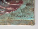a bronze statue of a woman sitting on a table