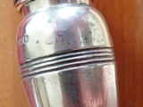 a silver salt and pepper shaker on a wooden table