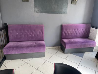 deux canapés violets dans un coin de la pièce