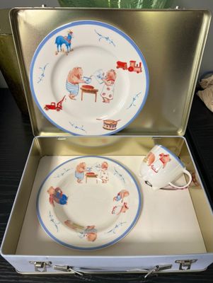 deux assiettes et une tasse dans une valise posée sur une table