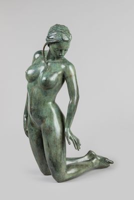 une image représentant une statue en bronze d'une femme assise par terre