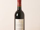 a bottle of red wine sitting on a wooden table