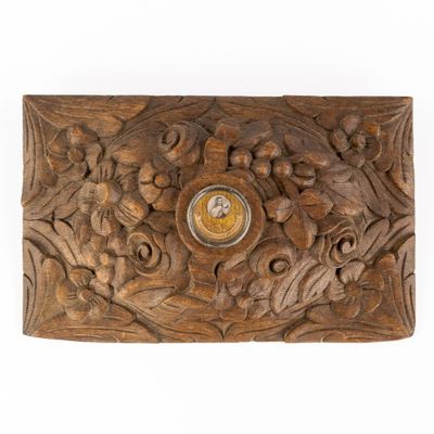 carved wooden box with a clock in the middle of it