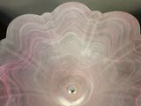 a glass bowl that has a pink swirl on it