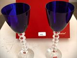 deux verres à vin posés sur une table, à côté d'une boîte rouge