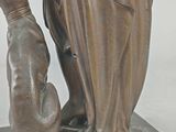 bronze statue of a woman and a dog on a marble base