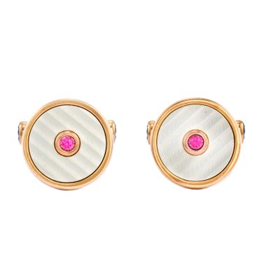 un gros plan sur une paire de boutons de manchette roses et blancs