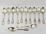 six silver spoons and six spoons are lined up on a white surface