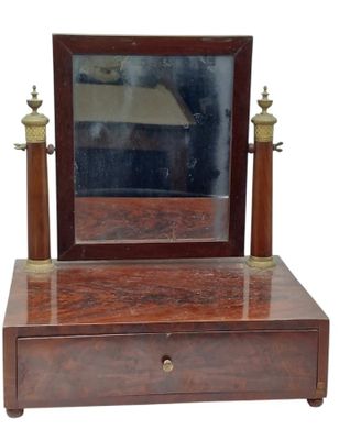 a small wooden vanity with a mirror on it