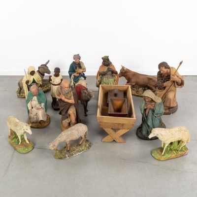 many figurines of people and animals that are on the floor