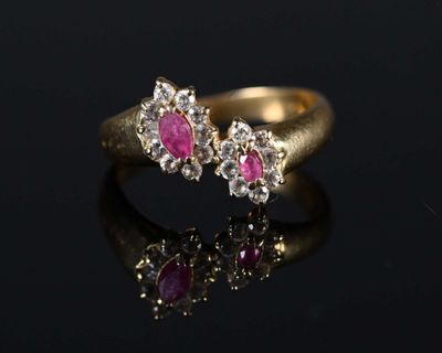 a close up of a gold ring with pink stones on a black surface