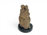statue of a woman holding a child on a marble base