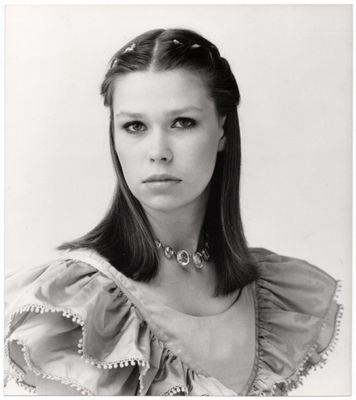 photographie en noir et blanc d'une femme en robe, portant un collier