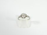 a close up of a diamond ring on a white surface