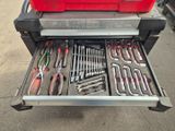 une boîte à outils rouge contenant des outils, posée à l'arrière d'un camion