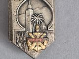 deux insignes en argent et en or sur lesquels figurent un phare et un palmier