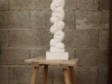 a white sculpture sitting on a small wooden table